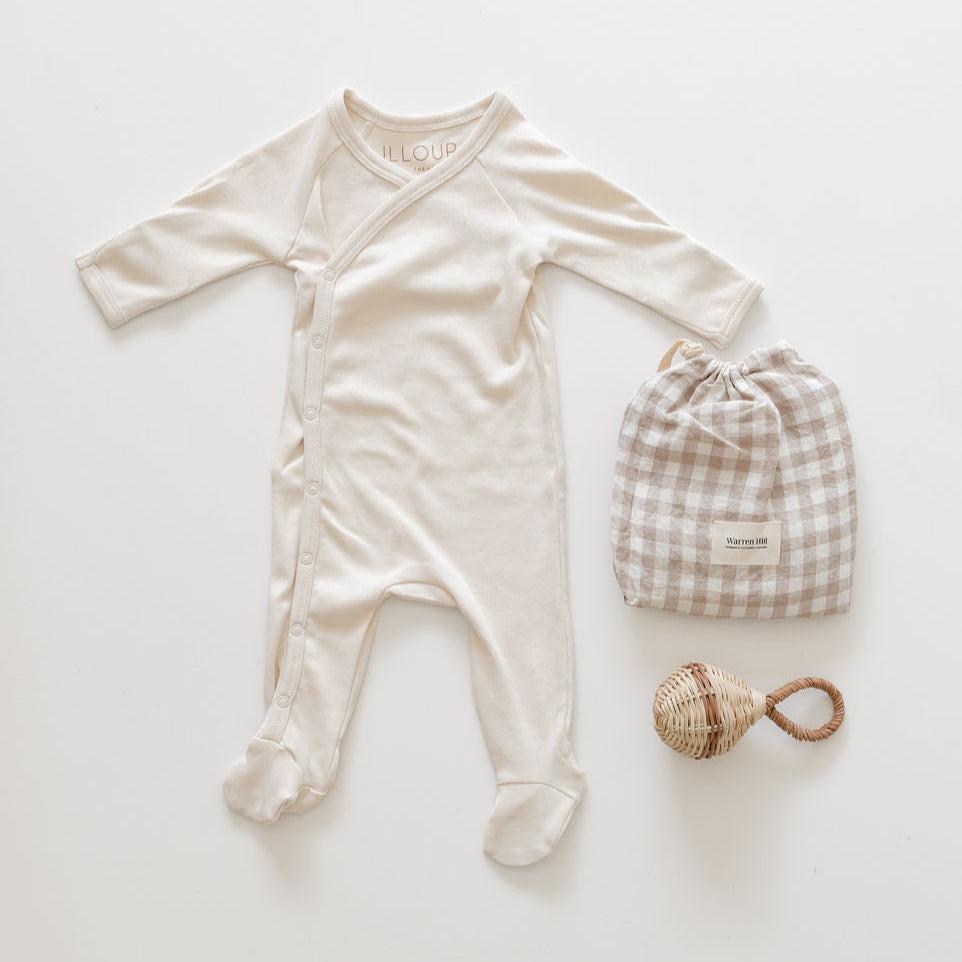 A biglittlegifting baby romper and a toy on a white surface.
