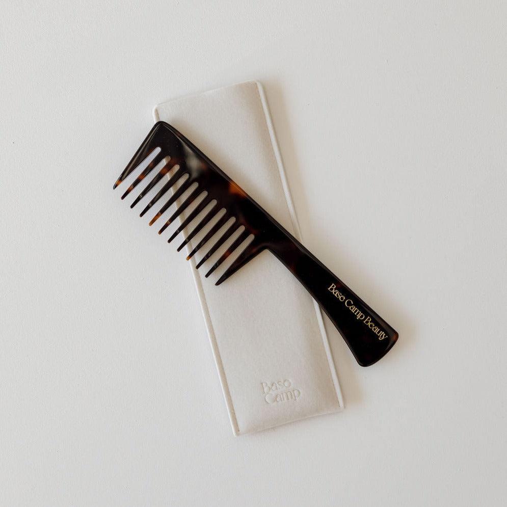 A grand comb on top of a white cloth.