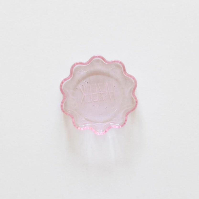 A small piece of Fazeek pink wave incense holder on a white surface.
