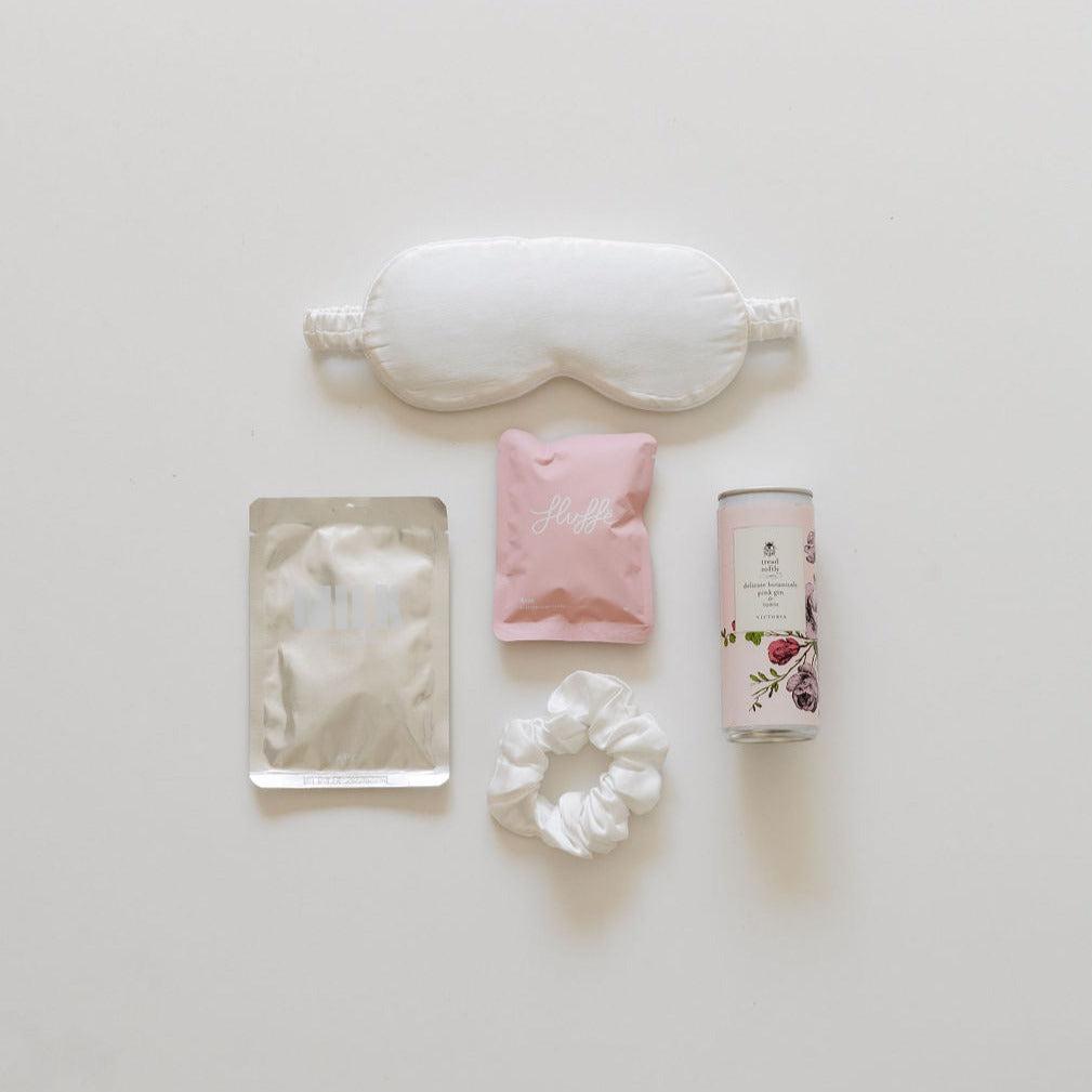 Another little bridesmaid gift, eye mask, and other items are laid out on a white surface.