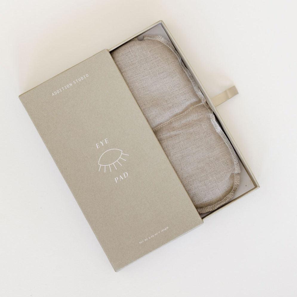 A box with an Addition Studio aromatherapy eye pad and a swaddle blanket inside.