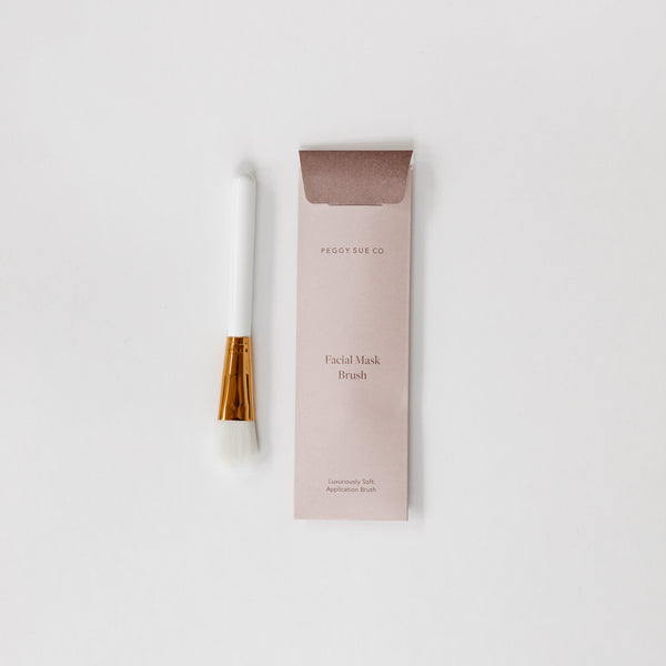 A white face mask kit with a gold handle on a white surface, perfect for any beauty lover or as a thoughtful gift. (Brand: biglittlegifting)