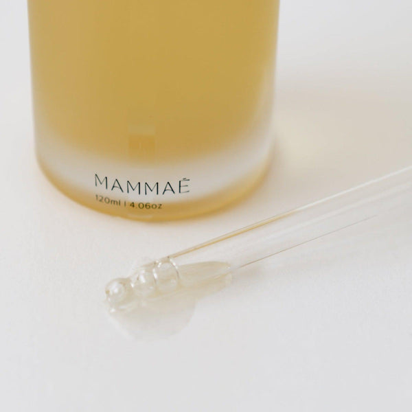 A bottle of Mammae, a bosom ritual elixir lactation support supplement, accompanied by a syringe.