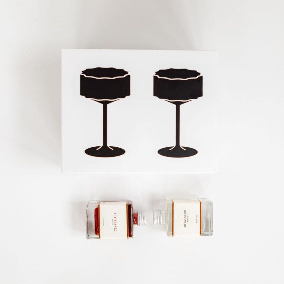 A bottle of the cocktail kit from biglittlegifting and a bottle of wine, perfect for crafting cocktails or as a gift.