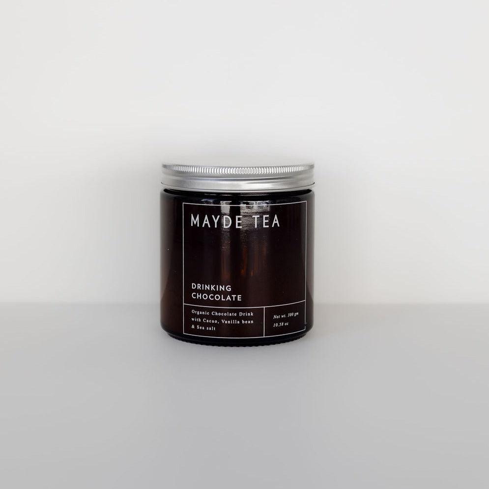 A jar with a Mayde Tea naturally sweetened drinking chocolate candle on a white background.