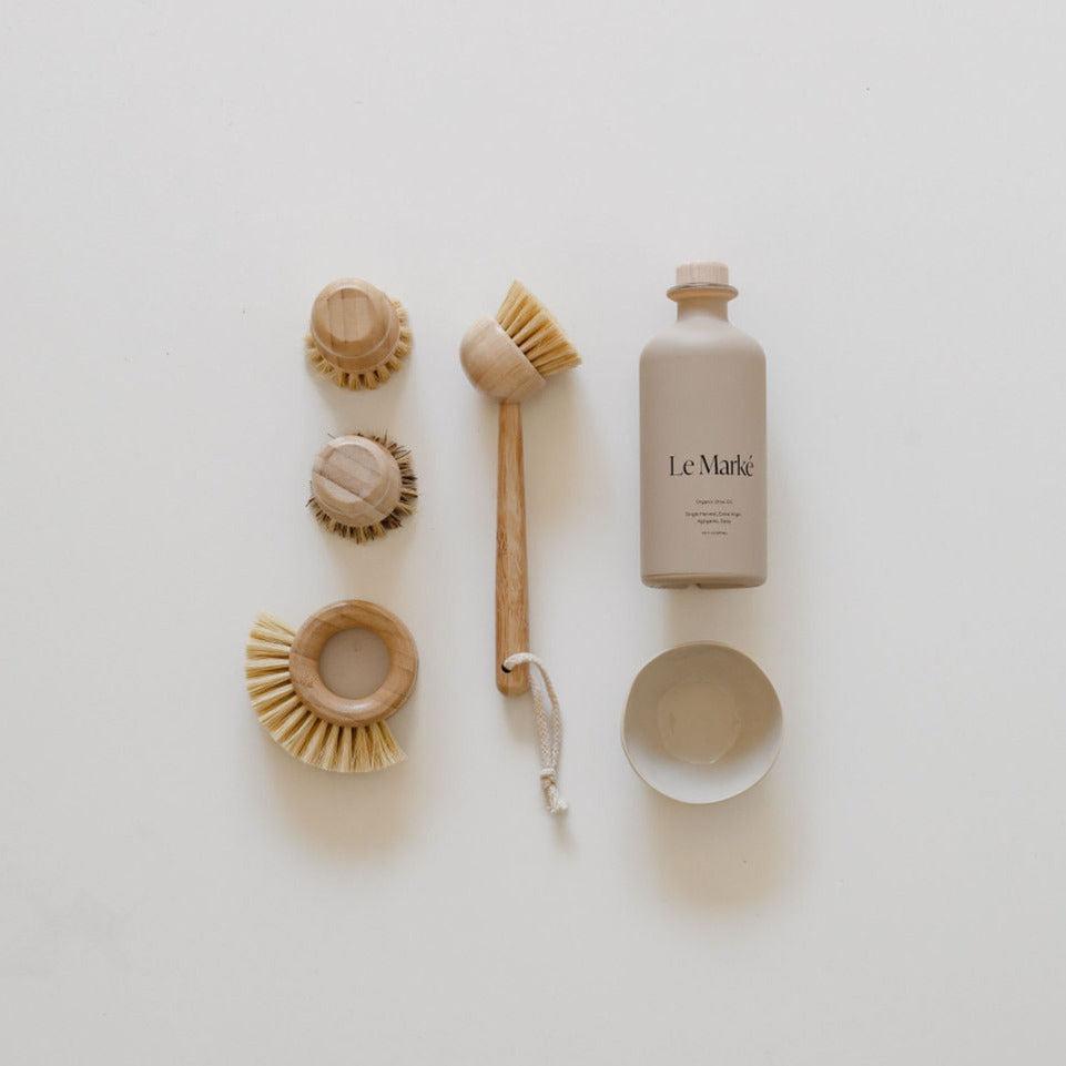 A set of elevated everyday essentials brushes and an elevated everyday essentials bottle on a white surface from biglittlegifting.