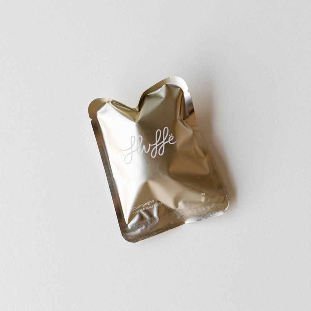 A Fluffe champagne foil packet on a white surface.
