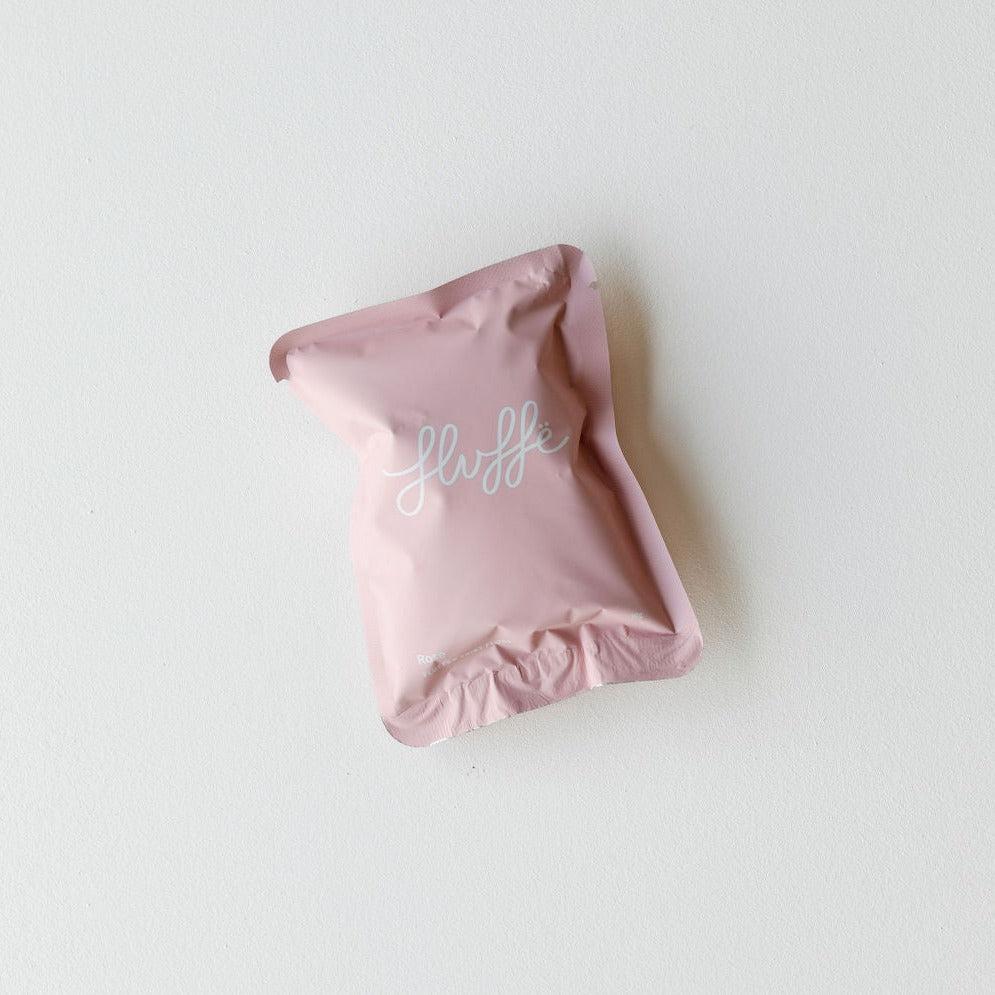 A pink pouch with the word "Fluffe fairy floss | rose" on it. (Brand Name: Fluffe)