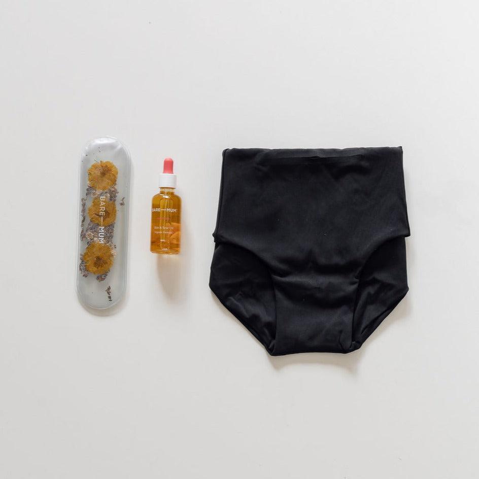 A pair of black underwear, a bottle of water, and a biglittlegifting brand for cesarean recovery.
