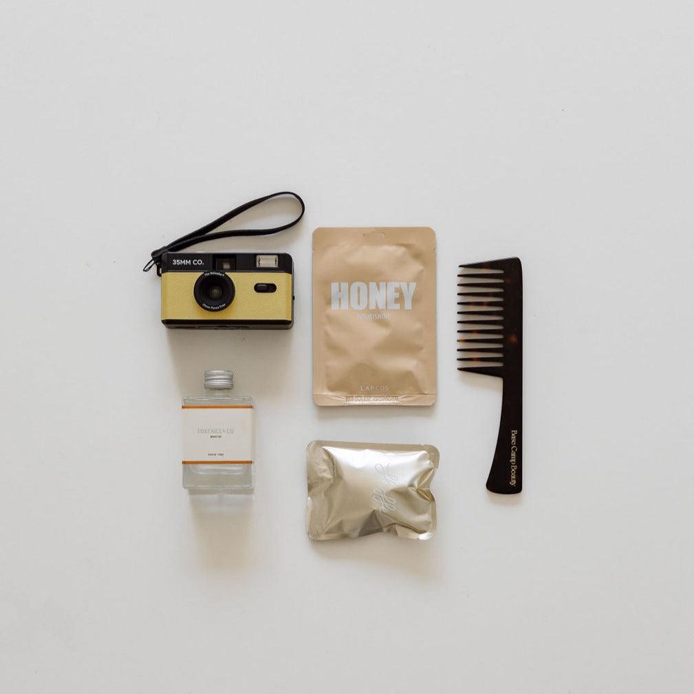 A Gals Night In camera, comb, and other items are laid out on a white surface by BigLittleGifting.