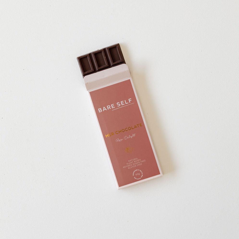 A bar of Rose Delight sitting on a white surface, perfect for indulging and satisfying your cravings. With its rich taste and smooth texture, this bar of Her Chocolate from Bare Self is not only a delightful treat.
