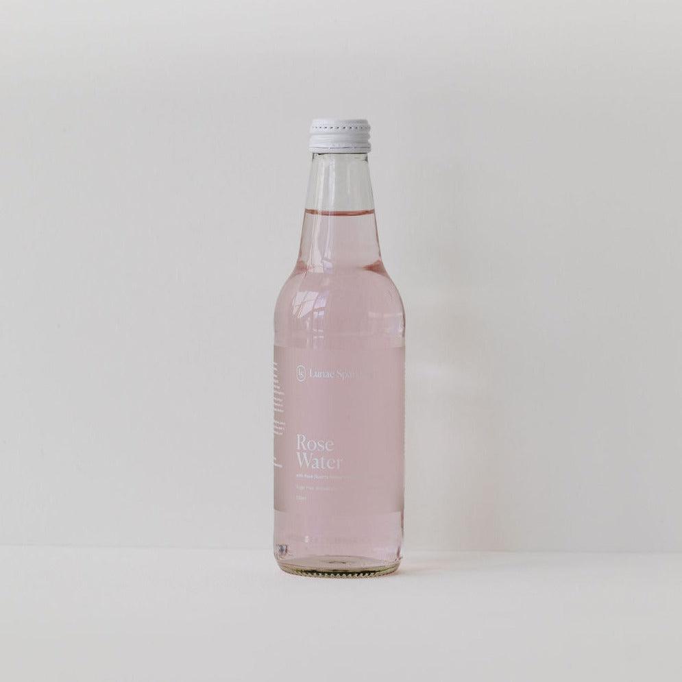 A bottle of Lunae Sparkling gluten-free rose water on a white background.