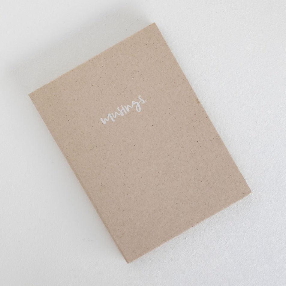 A Emma Kate Co musings petite notebook with the word love written on it.