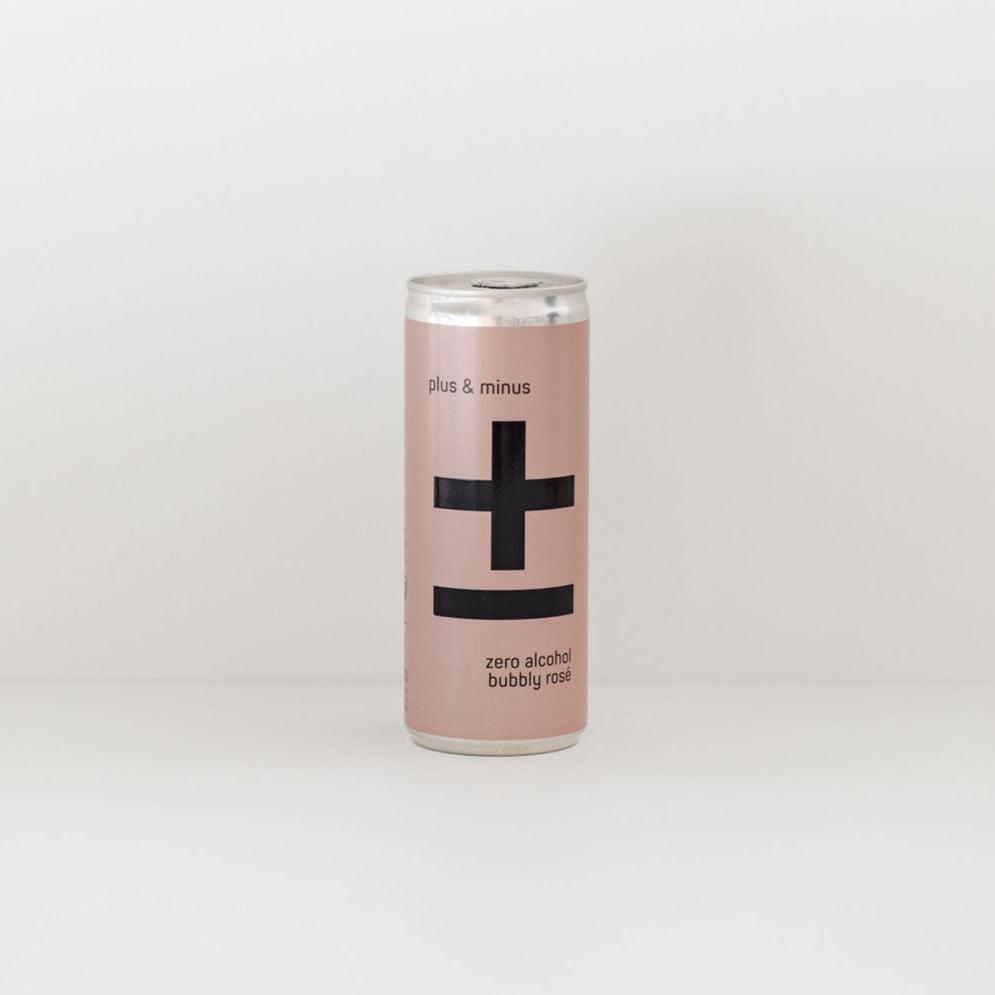 A can of Plus & Minus non-alcoholic rosé with a large black plus and minus sign on a pale pink background.