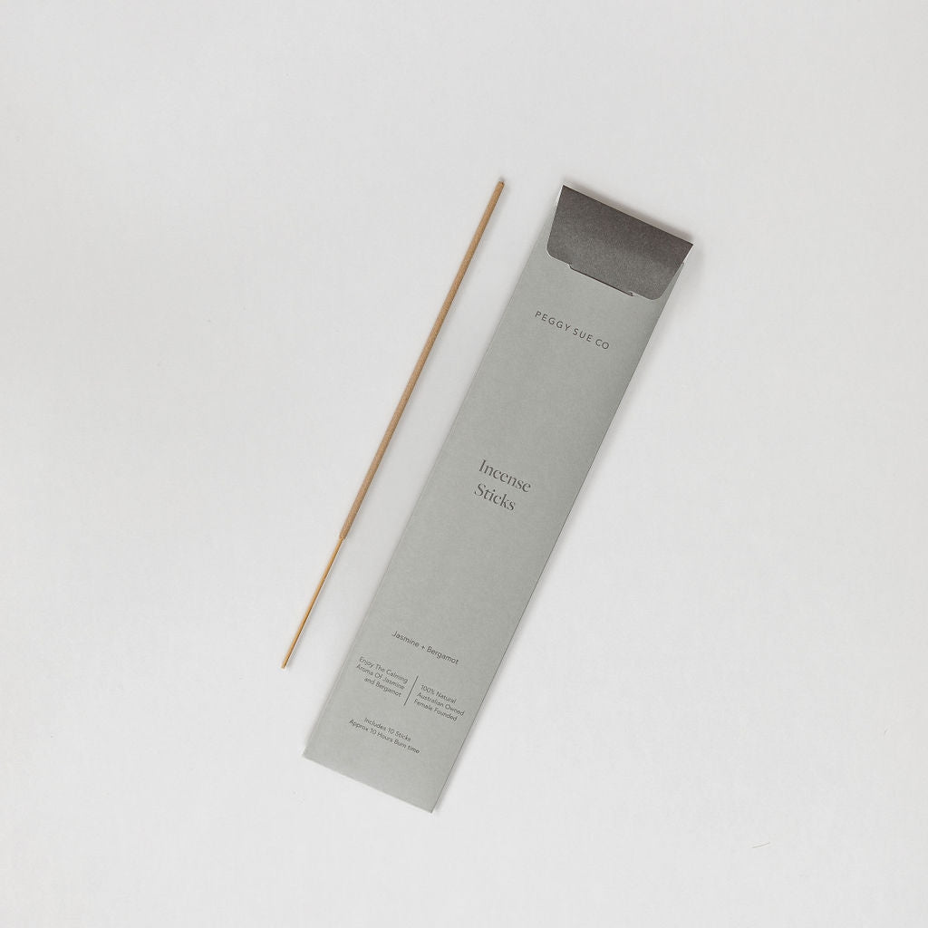 A Peggy Sue Co. Calming Incense Stick in jasmine + bergamot on a white surface.