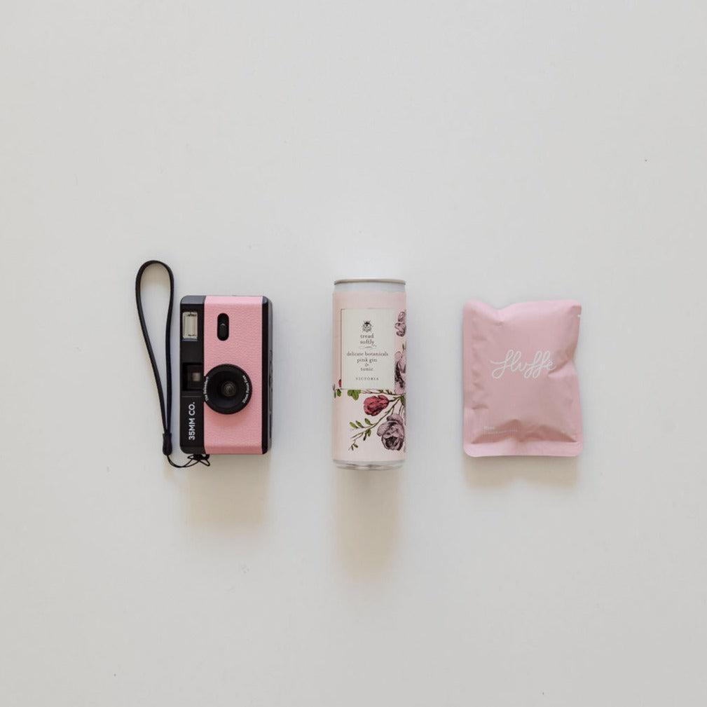 A picture perfect pairing from biglittlegifting, consisting of a pretty in pink camera and a pink bag next to it.