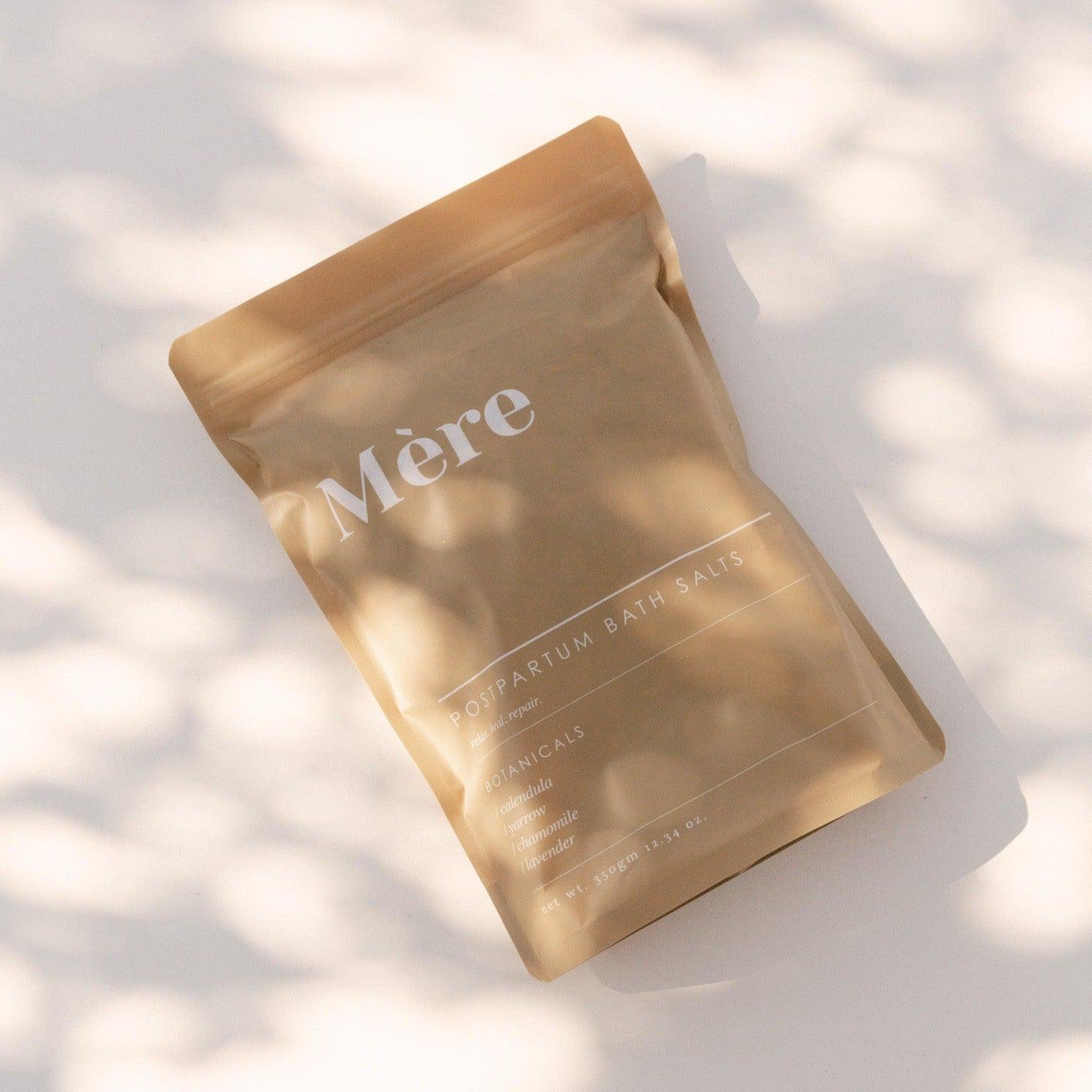 A calming bag with the word 'more' on it, called Postpartum Bath Salts by Mère.