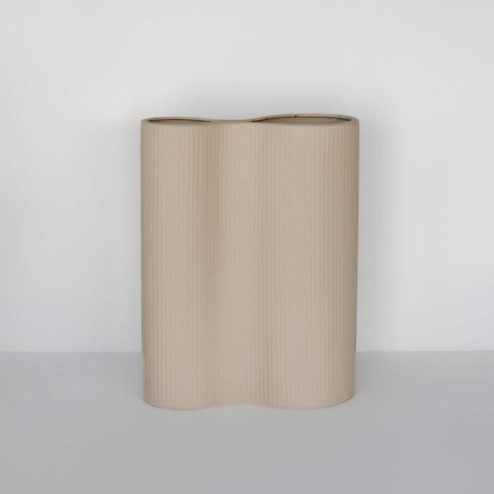 A ribbed infinity vase in cream by Marmoset Found stands upright against a plain white background.