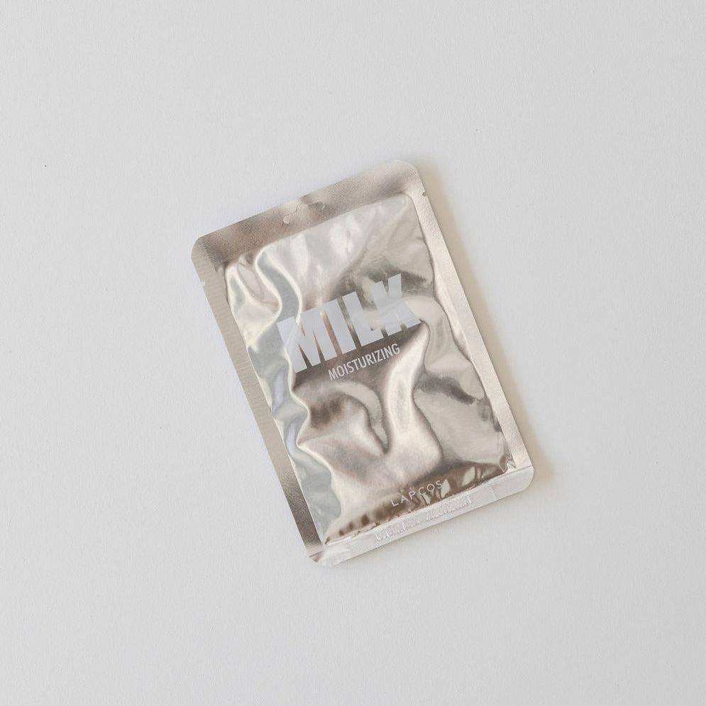A Lapcos moisturising sheet face mask in a silver foil packet on a white surface.