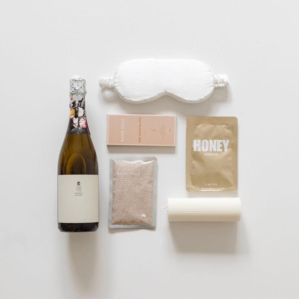 A bottle of The Big Relax wine, a bottle of The Big Relax honey, and other items on a white surface. (Brand Name: Big Little Gifting)