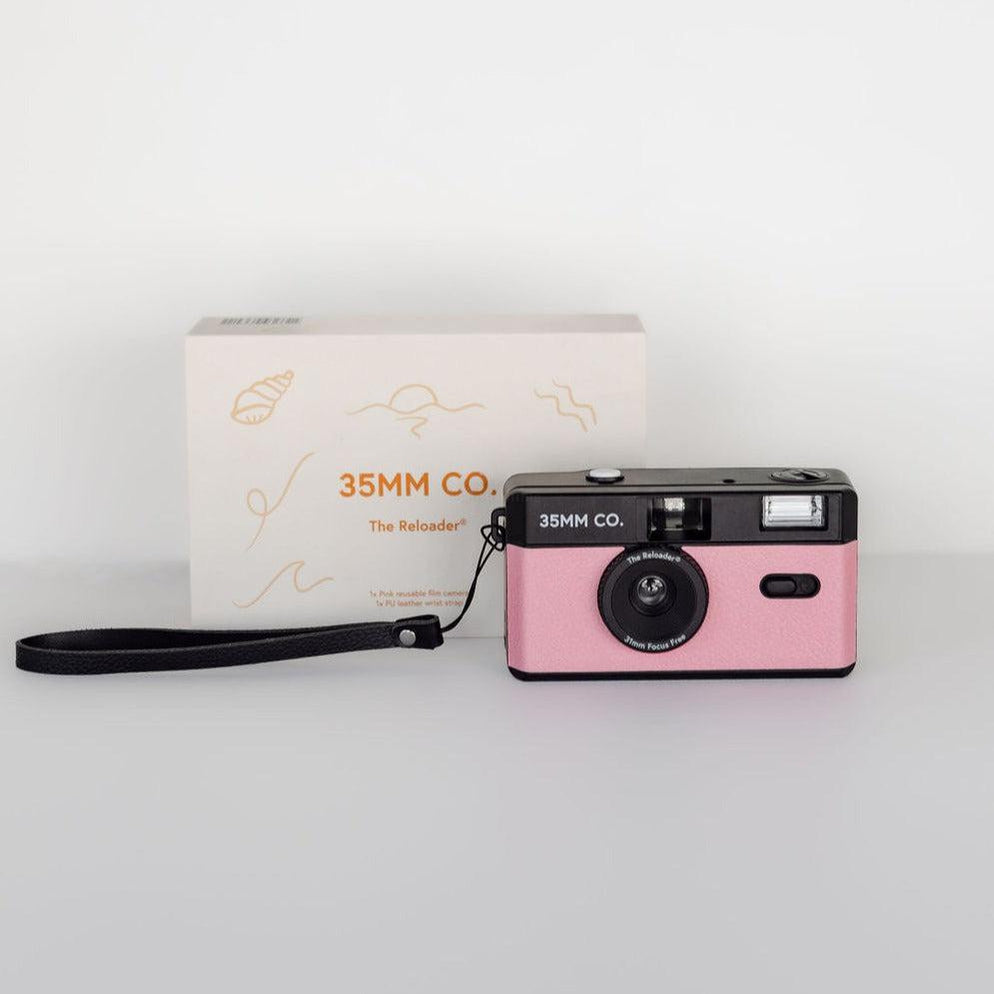 A 35mm camera with a dusty pink strap and box in front of it, the reloader® reusable film camera | dusty pink.