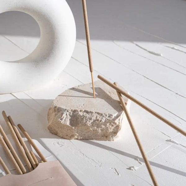 Travertine Incense Holder by Peggy Sue Co. on a white table next to a white vase.