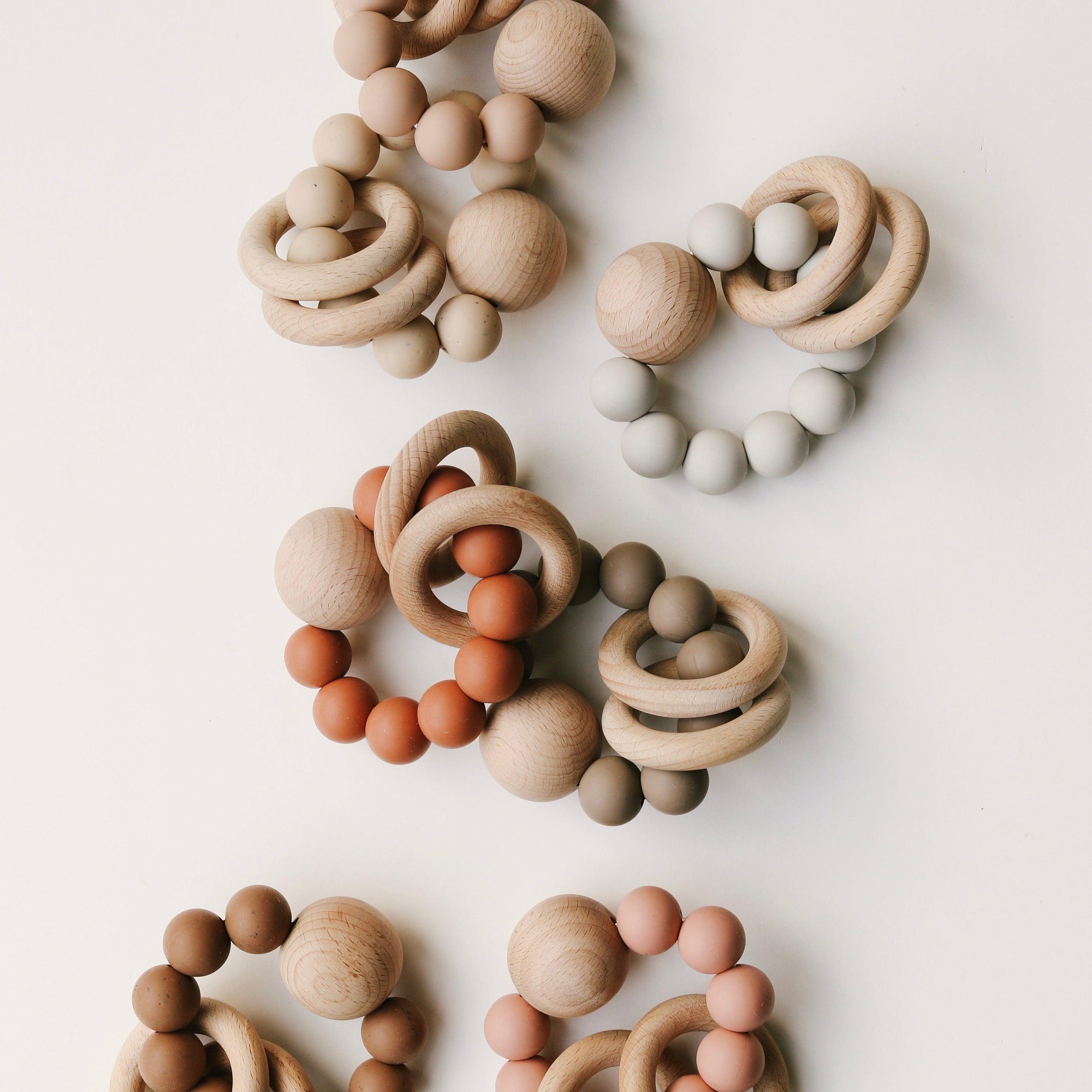 Assorted Dove & Dovelet wooden and BPA-free silicone bead teething necklaces on a white surface, meeting Australian Toy Safety Standards.