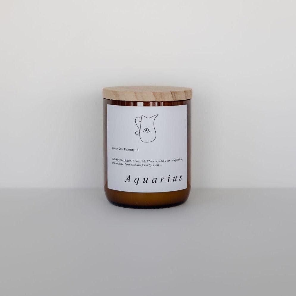 A zodiac candle from The Commonfolk Collective with the word aquarius written on it.