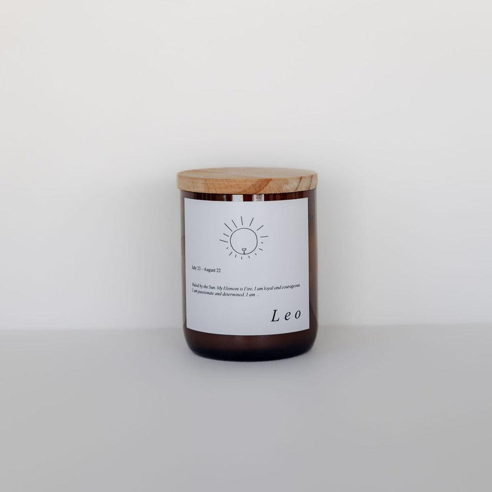Sentence with replaced product:
Zodiac candle with a wooden lid in a clear jar labeled "Leo" featuring an astrological sun symbol, crafted from soy candle wax, placed against a plain white background by The Commonfolk Collective.