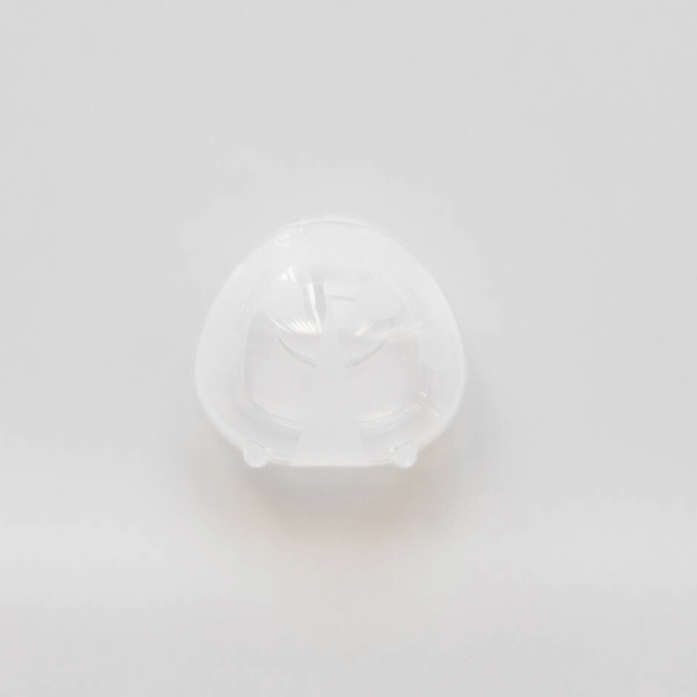 A Haakaa Ladybug Silicone Breast Milk Collector on a white surface.