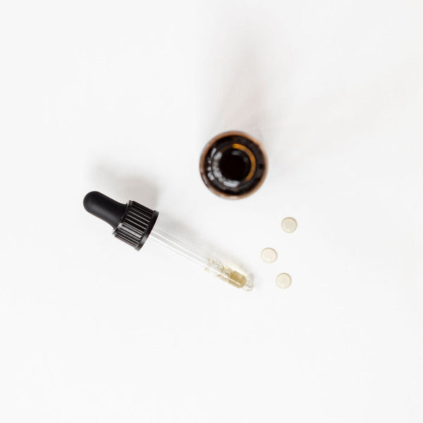 A bottle of Mama Goodness Zen Drops CBD oil on a white surface.